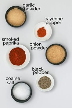four bowls with different types of spices in them on a white surface, including cayen pepper, cayen paprika, onion powder and coarse salt