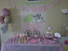 a baby shower party with pink and green decorations on the table, balloons in the background