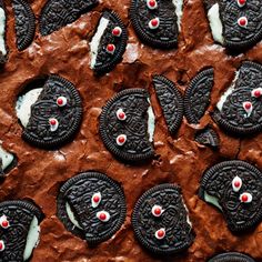 chocolate cookies with white frosting and red eyes are arranged on top of each other