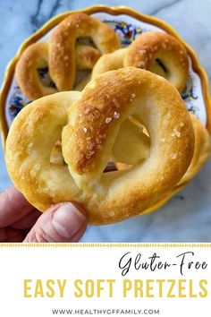 a person holding up two soft pretzels in front of the words gluten - free easy soft pretzels