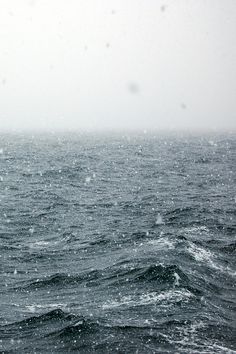 the ocean is covered in snow as it sits on top of an overcast day