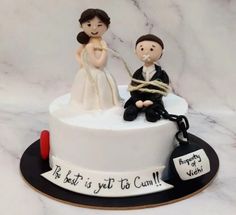 a wedding cake with a bride and groom tied up to each other on the top