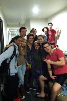 a group of young people posing for a photo in a room with an open door