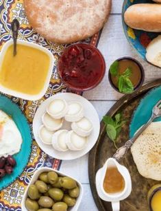 an assortment of food on plates with olives, bread and other foodstuffs