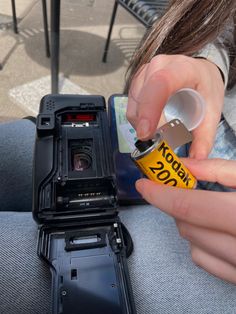 a woman is holding a camera and an empty can