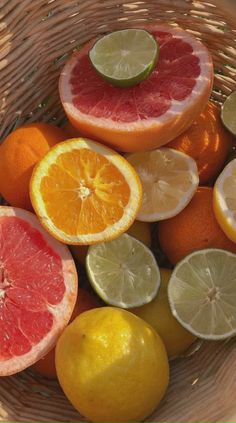 a basket filled with citrus fruit sitting on top of a table