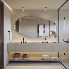 a bathroom with a large round mirror above the sink and two bowls on the counter