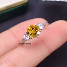 a yellow and white diamond ring on someone's finger