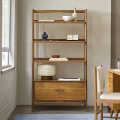 a wooden shelf with two vases and a clock on it next to a chair