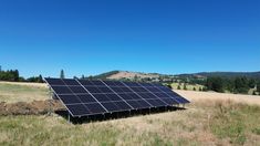 a solar panel in the middle of a field with mountains in the backgroud