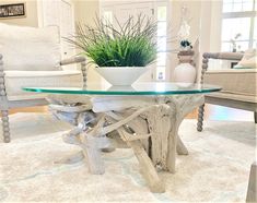 a glass table sitting on top of a white rug next to two chairs and a potted plant