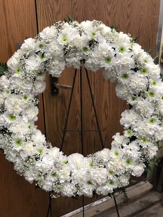 a wreath with white flowers on a stand