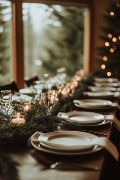 a long table is set with place settings and lit candles for the dinner guests to enjoy