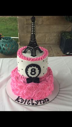 a three tiered cake with the eiffel tower on top