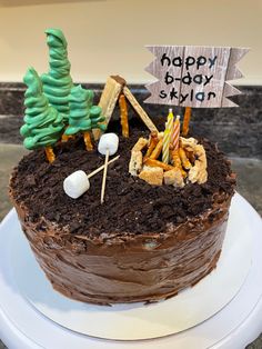 a chocolate cake with marshmallows and trees on top