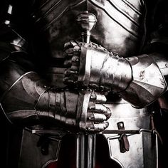 a close up of a knight's armor with his hands on the back of his arm