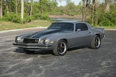 a gray muscle car parked in a parking lot