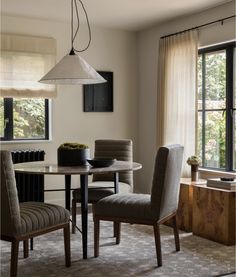 a dining room table and chairs in front of a window