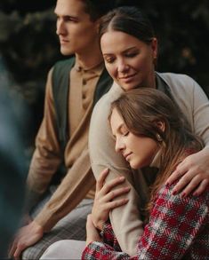 a man and woman sitting next to each other with their arms wrapped around one another