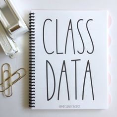 a notepad with the words class data next to office supplies on a white surface