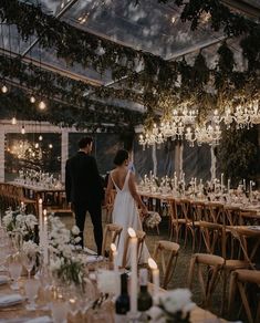 a bride and groom are standing in front of the reception tables