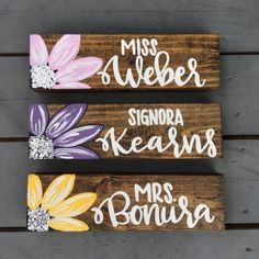 three wooden signs with flowers painted on them, one saying miss and the other saying mr and mrs