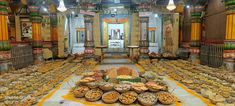 a room filled with lots of food on top of a white and yellow table cloth