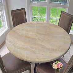 a round marble table with four chairs around it