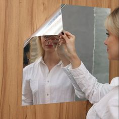 a woman is looking at herself in the mirror