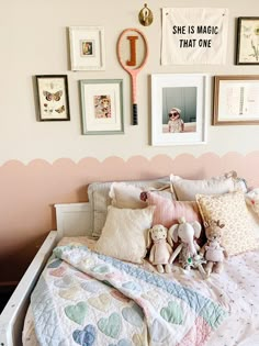 a child's bed with stuffed animals and pictures on the wall