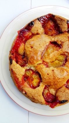 a fruit pie on a white plate sitting on a table