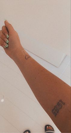 a woman's arm with a tattoo on it and her foot in the air