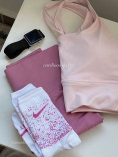 a pink sports bra top, leggings and cell phone on a white table