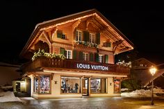 the store front of louis vuitton is lit up with christmas lights and garlands