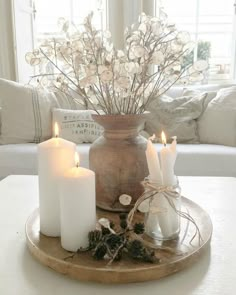 some white candles are sitting on a tray