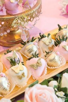 chocolate covered strawberries are on a tray with pink flowers and gold decorations in the background