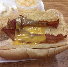 a hot dog with bacon and cheese on it