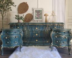 an ornate blue dresser with gold accents and white furnishing in a living room