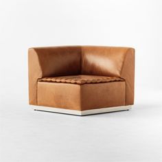 a brown leather chair sitting on top of a white floor