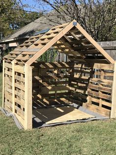 a wooden structure made out of pallets in the grass