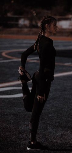 a woman standing in the middle of a parking lot with her hands on her hips