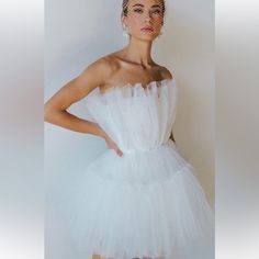 a woman in a white dress with a veil on her head is posing for the camera