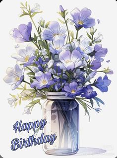 a blue vase filled with purple flowers on top of a white table next to a sign that says happy birthday