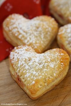 some heart shaped pastries are on a cutting board