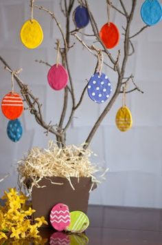 an easter tree with painted eggs hanging from it