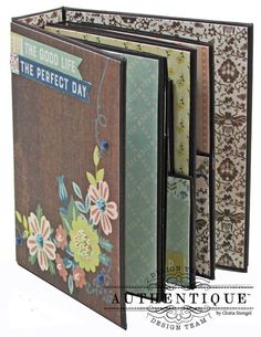 an open book with floral designs on the front and back cover, which is attached to a clipboard