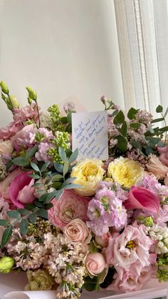 a bouquet of flowers sitting on top of a table next to a sign that says thank you