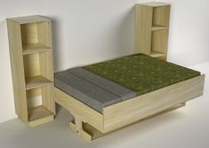 a bed and bookcase made out of wood with green fabric on the top, sitting next to each other