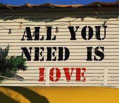 a sign that says all you need is love on the side of a garage door