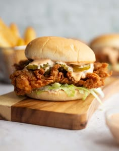 a chicken sandwich is sitting on a cutting board